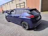 a blue car that is parked in a parking lot