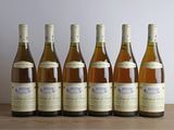 six bouteilles de vin sont alignées sur une table en bois