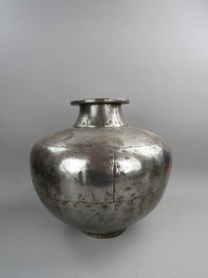 a silver vase that is sitting on a table