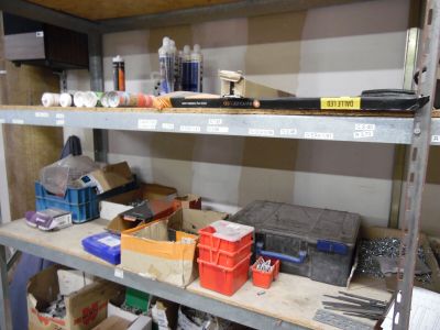 une étagère sur laquelle sont posés de nombreux outils différents, dans une pièce