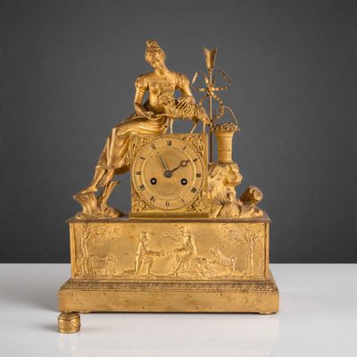 l'image d'une horloge en or sur laquelle est assise une femme
