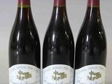 trois bouteilles de vin rouge sont alignées sur une table
