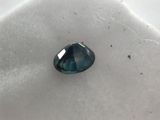 a close up of a blue diamond sitting on top of a white surface