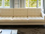 a white couch sitting in front of a window in a living room