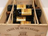 several bottles of wine are in a wooden box on a table