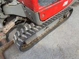 a small red tractor with a big tire on the ground
