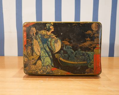 une petite boîte en métal sur laquelle est peinte une image