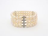 un gros plan sur un bracelet blanc orné de perles
