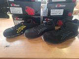 trois paires de chaussures de basket noires et jaunes posées sur une table en bois
