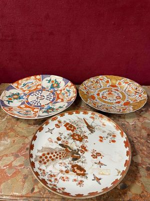 trois assiettes posées sur une table, avec un mur rouge en arrière-plan