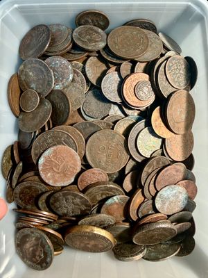 un récipient blanc rempli de pièces de monnaie posé sur une table