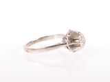 a close up of a diamond ring on a white surface