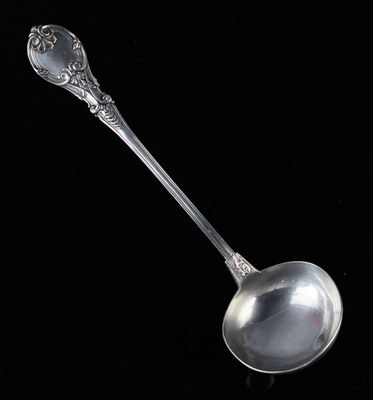 une cuillère en argent avec un manche, sur fond noir