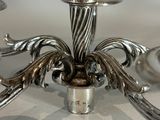 a silver candle holder that is on a table