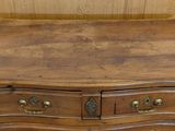 a small wooden chest of drawers on a wooden floor
