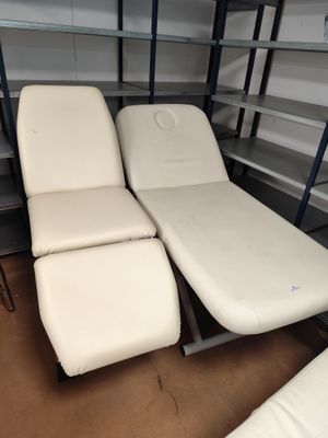 deux fauteuils inclinables blancs dans une pièce équipée d'étagères