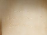 someone is writing on the wall of a bathroom with a toilet in it