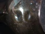 a close up of a silver tea pot on a table