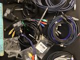 a lot of cables and remote controls on the table