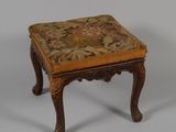 un petit tabouret en bois avec une assise rembourrée à motifs floraux