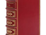 un livre rouge posé sur une surface blanche