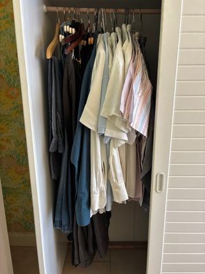 an image of a closet with clothes hanging in it
