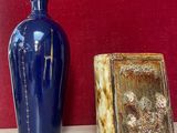 deux vases posés sur une étagère près d'un mur rouge