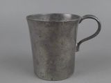 une coupe en argent munie d'une anse, sur fond gris