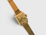 an image of a gold colored watch with a square face