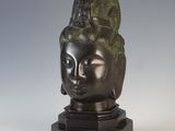 a bronze statue of a woman ' s head on a black base