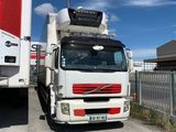 un camion blanc garé à côté d'un camion rouge et blanc