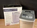 a small machine sitting next to a box on a table
