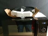 a microwave that has a box on top of it