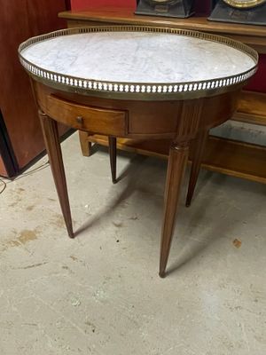 une petite table avec un plateau en marbre dans une pièce