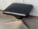 un fauteuil en cuir noir posé sur un sol en béton