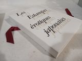 a book that is laying on a bed with a red ribbon