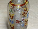 a glass jar with a design on it sitting on a table