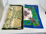 two pieces of cloth on a bed with a white sheet