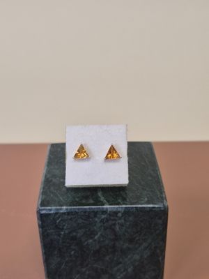 un gros plan sur une paire de boucles d'oreilles posées sur un bloc de marbre