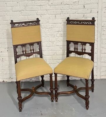 these are two chairs with yellow upholstered seats in front of a white brick wall