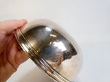 une personne qui tient un objet en argent dans la main