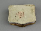 an antique porcelain box with writing on it sitting on a table