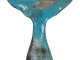 blue whale tail sculpture on wooden base on white background