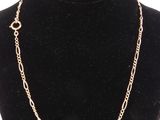 a gold chain necklace on a mannequin neck