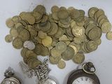 a pile of coins and a pocket watch on a table