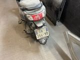 un scooter garé à côté d'une voiture dans un garage