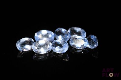 a close up of a group of blue sapphires on a black surface