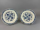a pair of blue and white plates with floral designs