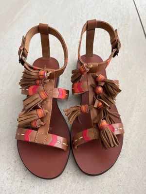 une paire de sandales pour femme ornées de franges et de pompons