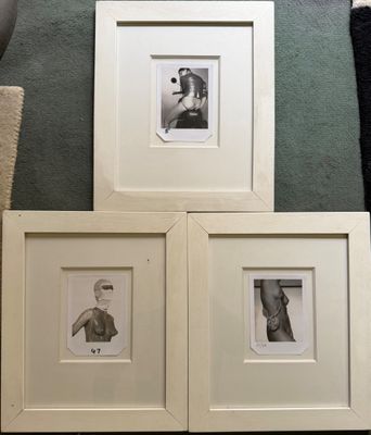 trois photos encadrées représentant un homme et une femme sont posées par terre
